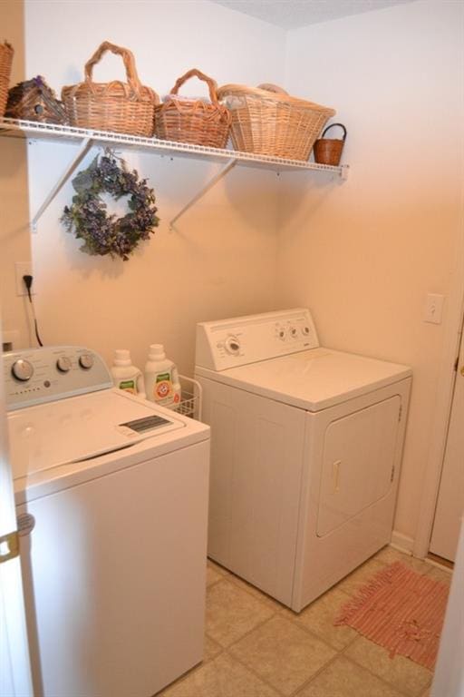 washroom with washer and clothes dryer and light tile patterned floors