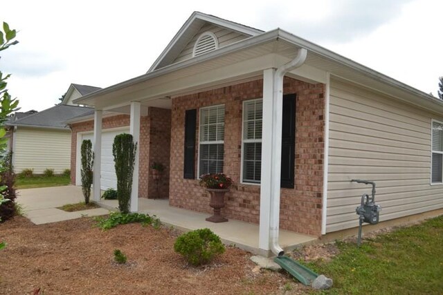 view of property exterior with a garage and a porch