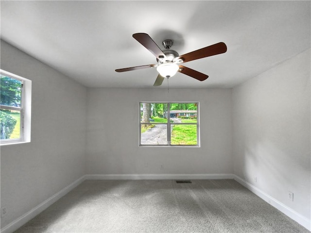 carpeted spare room featuring ceiling fan