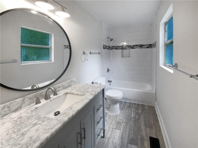 full bathroom with toilet, tiled shower / bath, and vanity