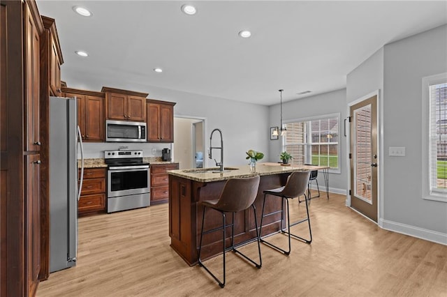 419 Highland Pointe Dr, Alto, GA 30510 - kitchen with appliances with stainless steel finishes, a sink, light wood-style flooring, a kitchen bar, and light stone countertops