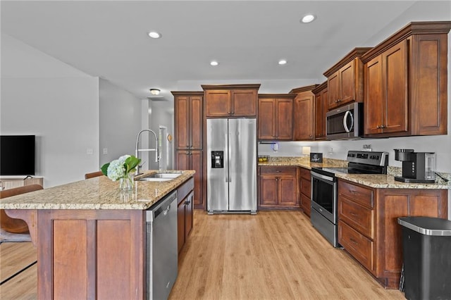 419 Highland Pointe Dr, Alto, GA 30510 - kitchen with appliances with stainless steel finishes, a sink, light wood-style floors, a kitchen bar, and light stone countertops