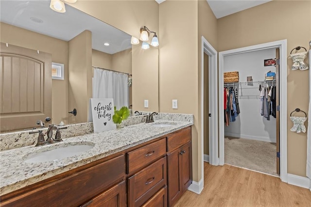 419 Highland Pointe Dr, Alto, GA 30510 - full bath with double vanity, wood finished floors, a walk in closet, and baseboards
