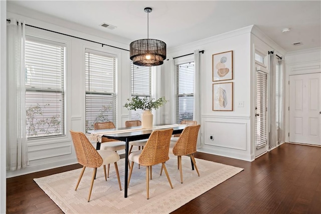 dining space with a wealth of natural light, dark wood-type flooring, and ornamental molding