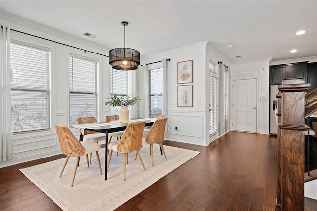 dining room with crown molding and dark wood-type flooring