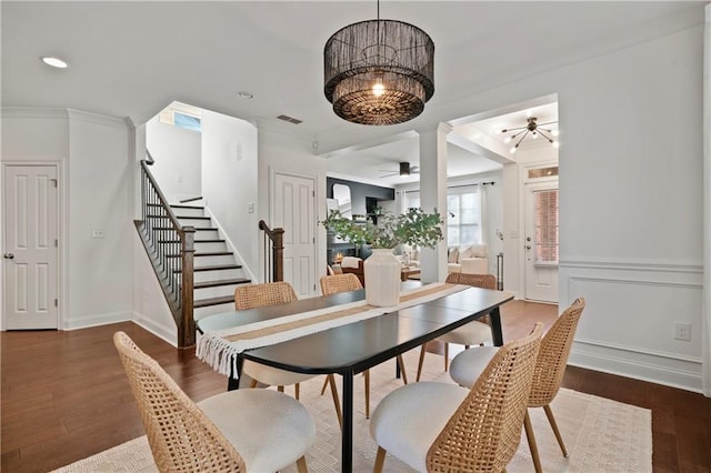 dining room featuring a chandelier, decorative columns, crown molding, and dark wood-type flooring