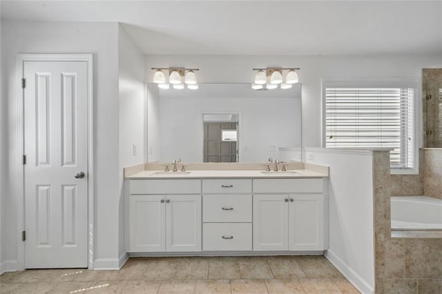 bathroom featuring tile patterned floors, vanity, and a relaxing tiled tub