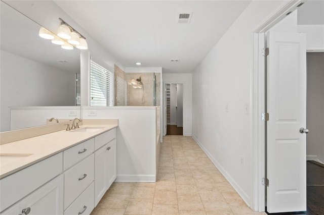 bathroom with tile patterned floors, vanity, and tiled shower