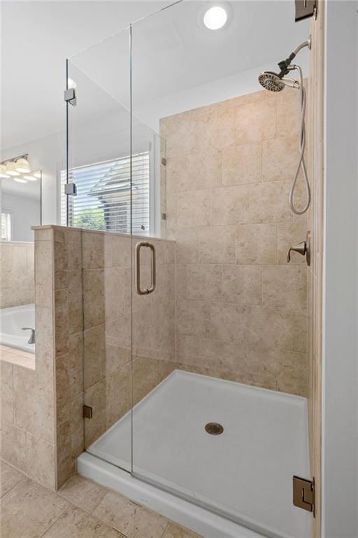 bathroom featuring plenty of natural light and shower with separate bathtub