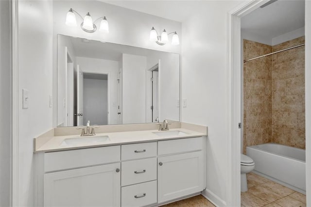 full bathroom with tile patterned floors, vanity, toilet, and tiled shower / bath combo