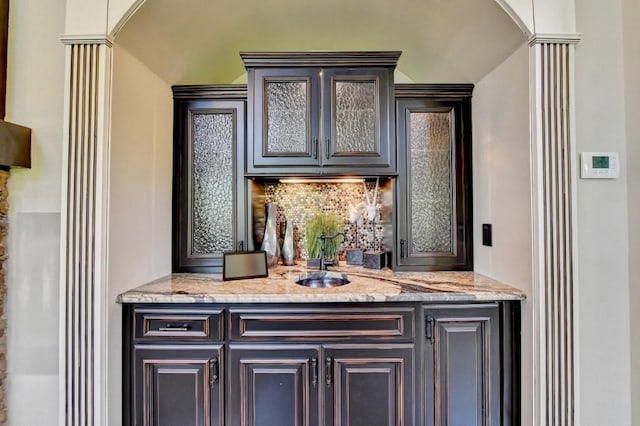 bar featuring a sink and backsplash