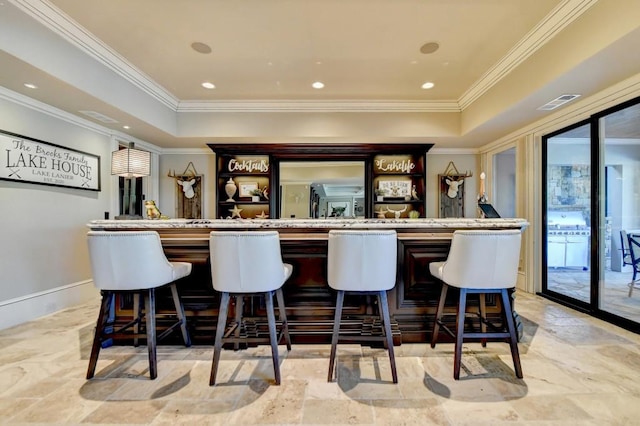 bar with crown molding, visible vents, a dry bar, and a raised ceiling