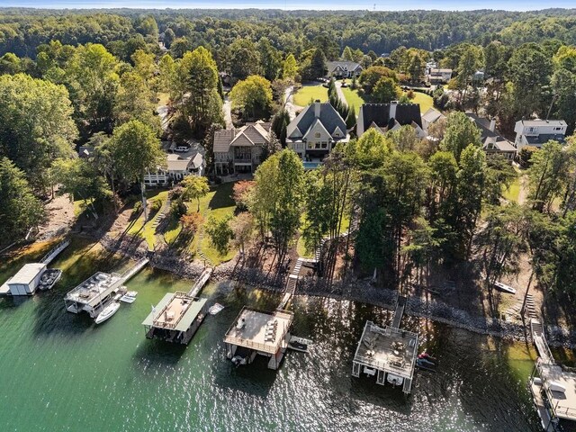 birds eye view of property featuring a water view and a wooded view