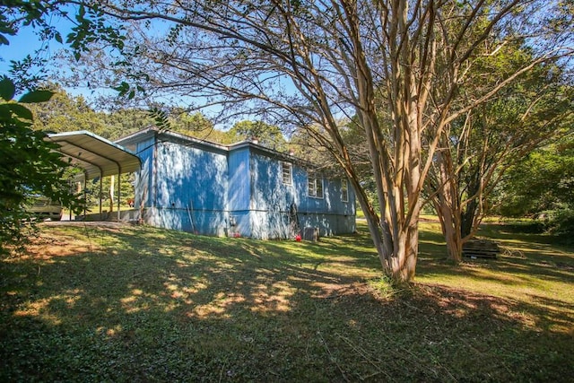 view of home's exterior featuring a carport and a lawn