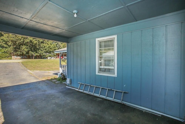 view of home's exterior with a lawn, board and batten siding, and a patio