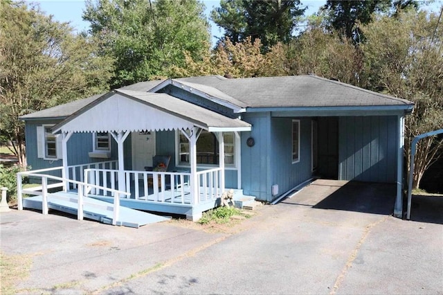 view of front of house with a porch, a carport, and a shingled roof