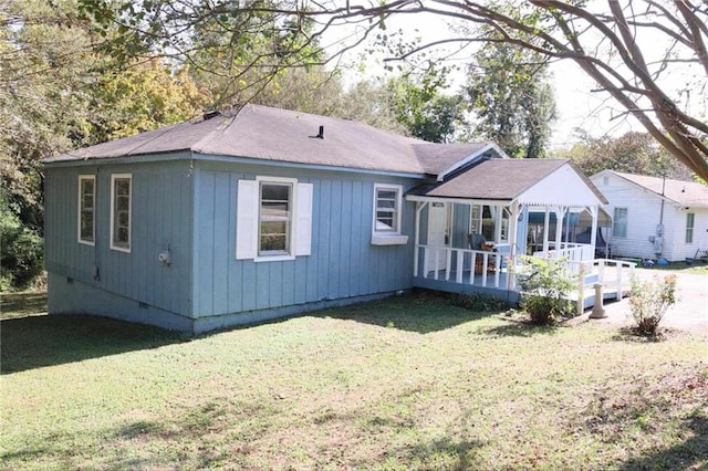 back of property with a deck, a yard, and crawl space