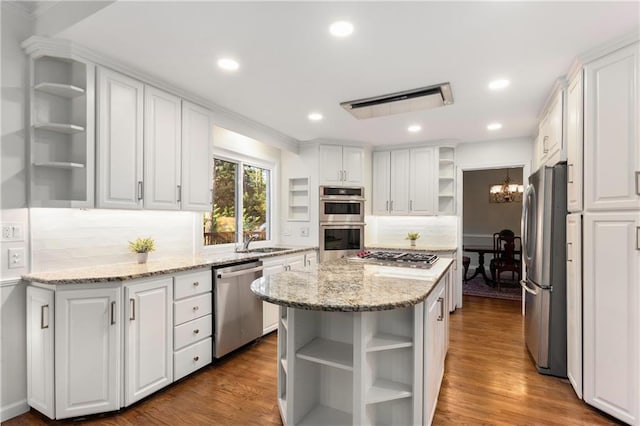 kitchen with a kitchen island, stainless steel appliances, and white cabinetry