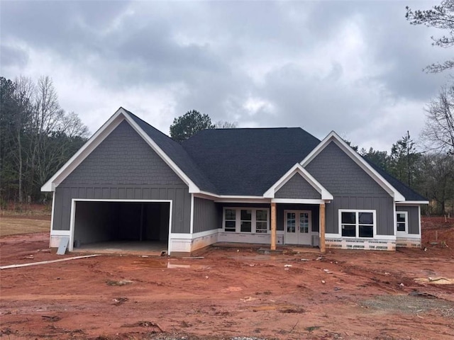 view of front facade featuring board and batten siding, french doors, and an attached garage