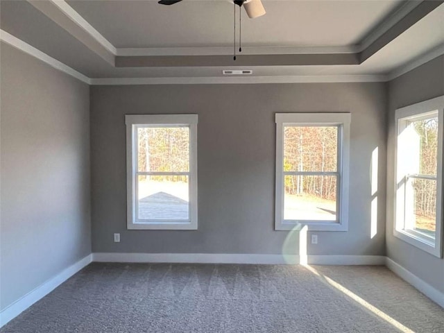 unfurnished room featuring dark colored carpet, ornamental molding, a raised ceiling, and visible vents