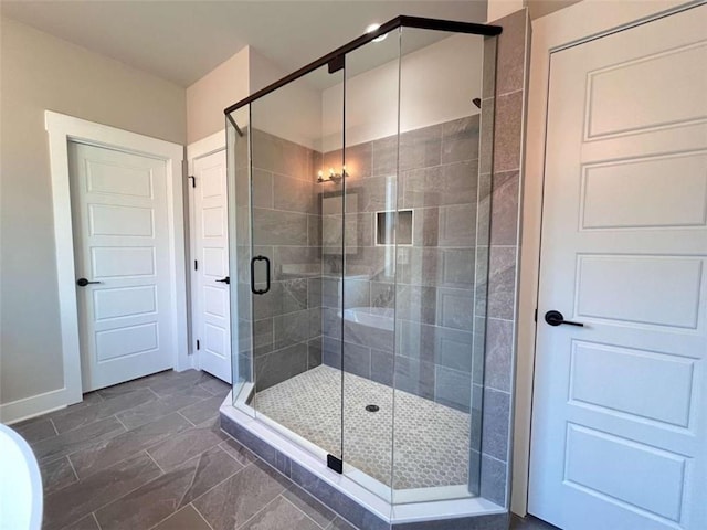 bathroom featuring a stall shower and baseboards