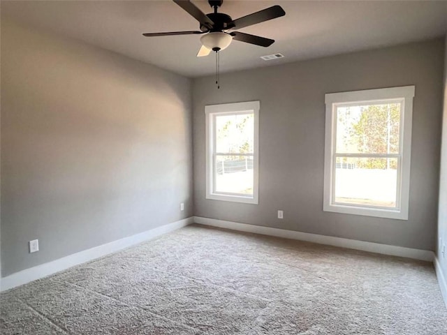 unfurnished room with light carpet, ceiling fan, visible vents, and baseboards