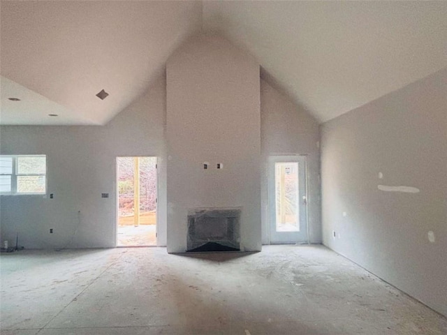 unfurnished living room featuring high vaulted ceiling and a fireplace