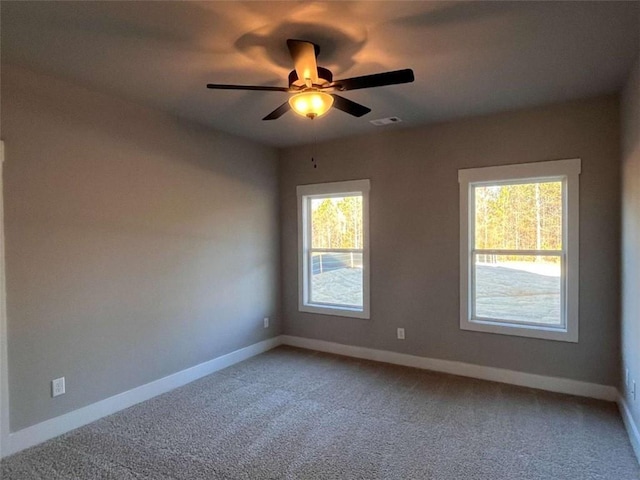 spare room featuring light carpet, visible vents, baseboards, and a ceiling fan