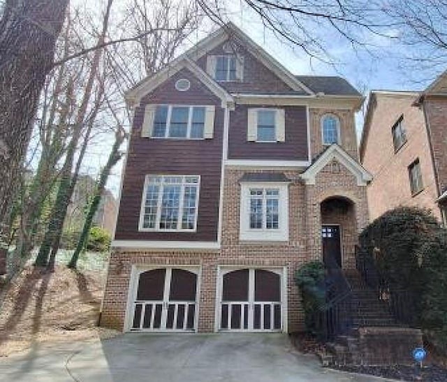 view of front of home featuring brick siding, a garage, and driveway