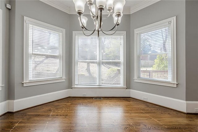 unfurnished dining area with crown molding, wood finished floors, visible vents, and a chandelier