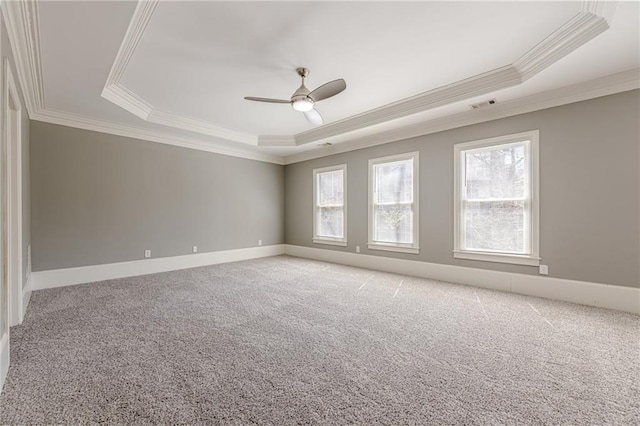 spare room featuring visible vents, a raised ceiling, and light carpet