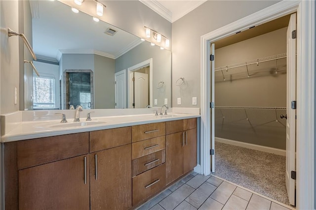 bathroom featuring tile patterned floors, visible vents, a sink, crown molding, and a spacious closet