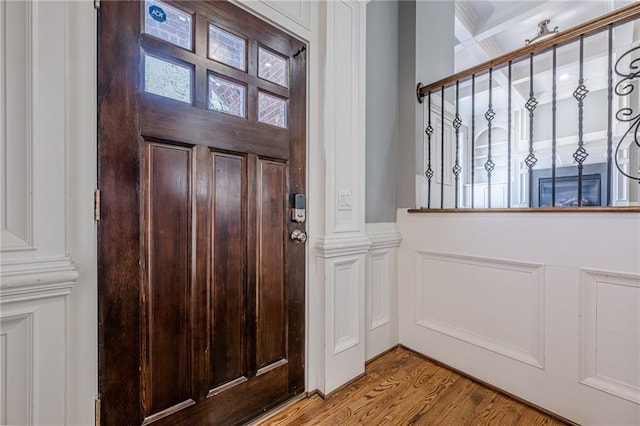 entrance foyer with wood finished floors and a decorative wall