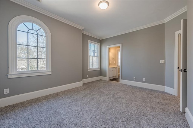 unfurnished bedroom featuring crown molding, multiple windows, carpet flooring, and baseboards