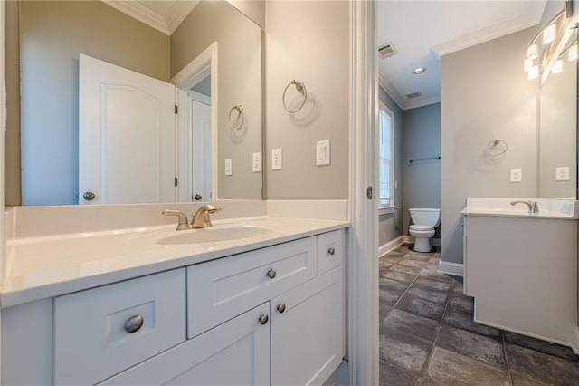 full bath with baseboards, two vanities, ornamental molding, a sink, and toilet