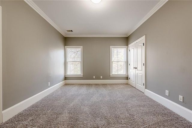 empty room featuring plenty of natural light, baseboards, and ornamental molding