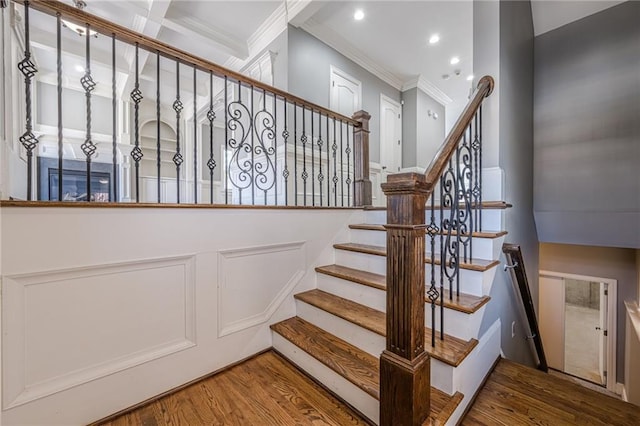 stairway with recessed lighting, wood finished floors, and ornamental molding