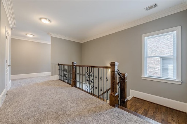 hallway with visible vents, an upstairs landing, crown molding, carpet flooring, and baseboards