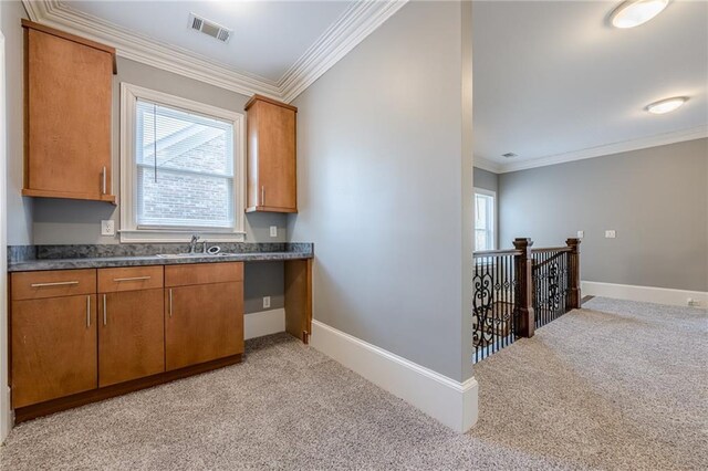 kitchen featuring a sink, visible vents, light carpet, and a wealth of natural light