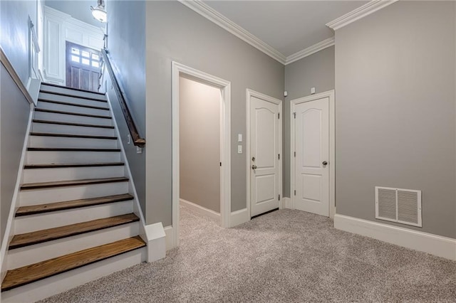 stairs featuring crown molding, baseboards, visible vents, and carpet floors