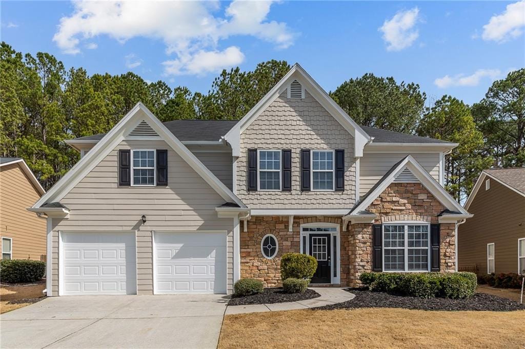 craftsman house featuring driveway, stone siding, and a garage