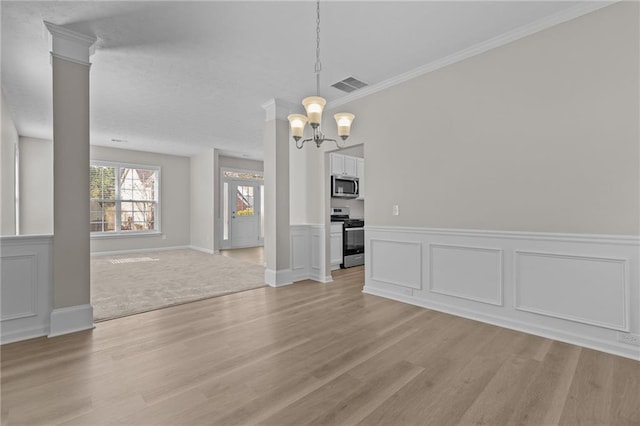 unfurnished dining area featuring light wood-style flooring, visible vents, an inviting chandelier, decorative columns, and crown molding