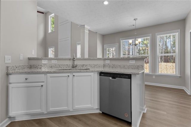 kitchen featuring a sink, light wood-type flooring, white cabinets, and stainless steel dishwasher