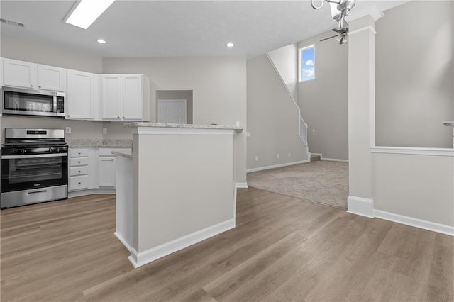 kitchen with light wood finished floors, visible vents, appliances with stainless steel finishes, and white cabinets