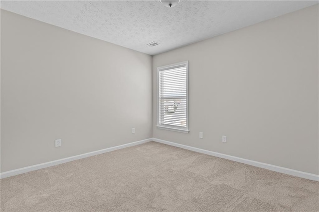 unfurnished room featuring visible vents, a textured ceiling, baseboards, and carpet flooring