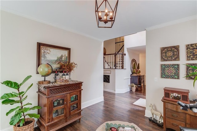 hall featuring crown molding, dark wood-type flooring, and a notable chandelier