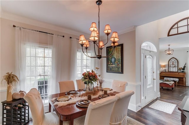 dining area with crown molding, a chandelier, and dark wood-type flooring