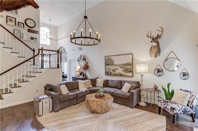 living room featuring wood-type flooring, a chandelier, and a high ceiling