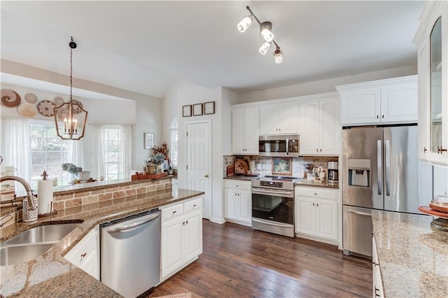 kitchen featuring pendant lighting, sink, white cabinets, stainless steel appliances, and light stone countertops