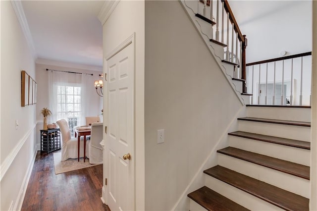 stairway featuring hardwood / wood-style floors, ornamental molding, and a chandelier